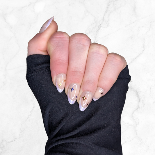 Image of a left hand wearing Snap Nails in Signature collection of 5 almond frosted french tips gold details on a marble background.