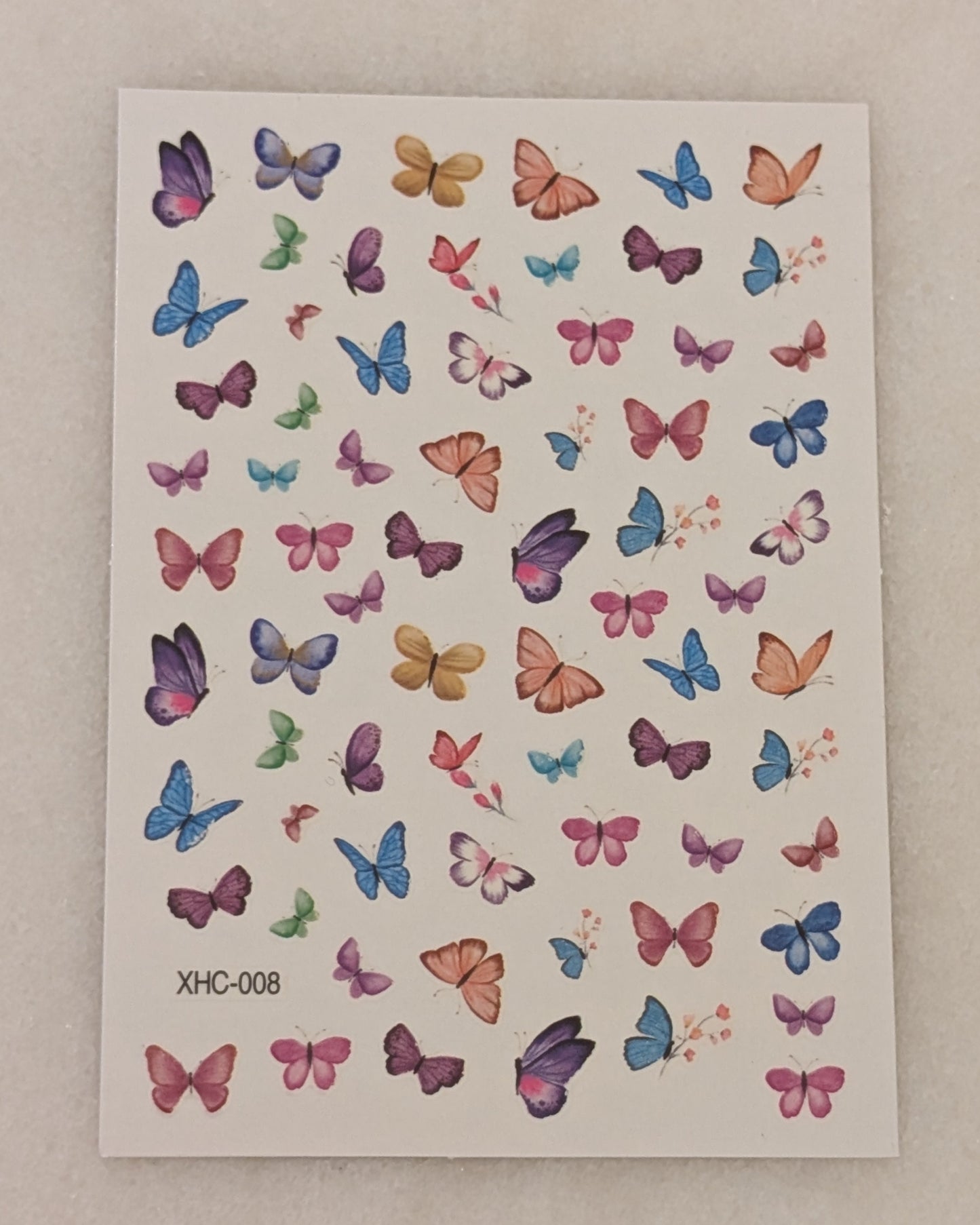 Nail art stickers with blue, yellow, orange, pink, purple and red butterflies.