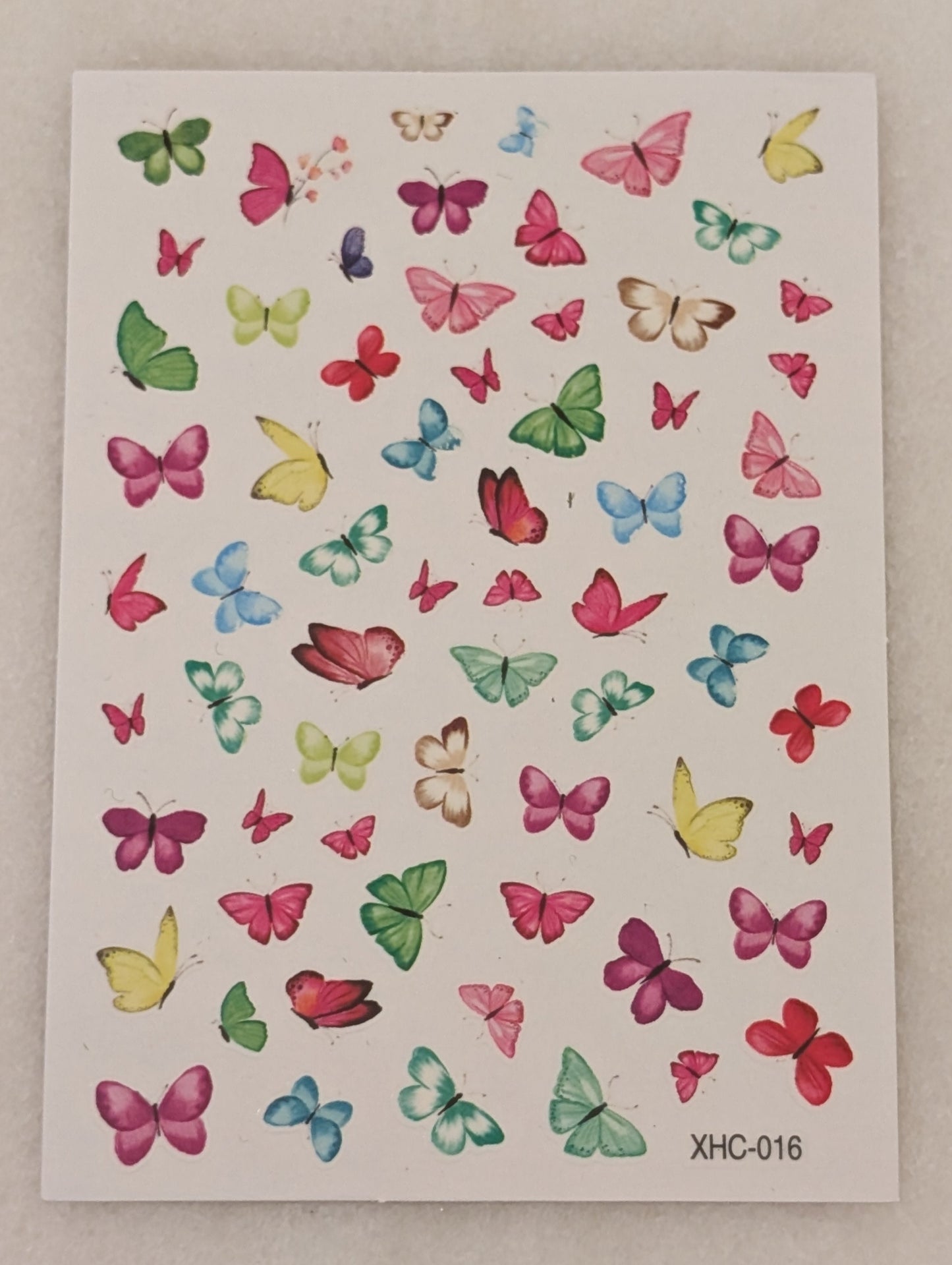 Nail art stickers with blue, yellow, green, pink, purple and red butterflies.