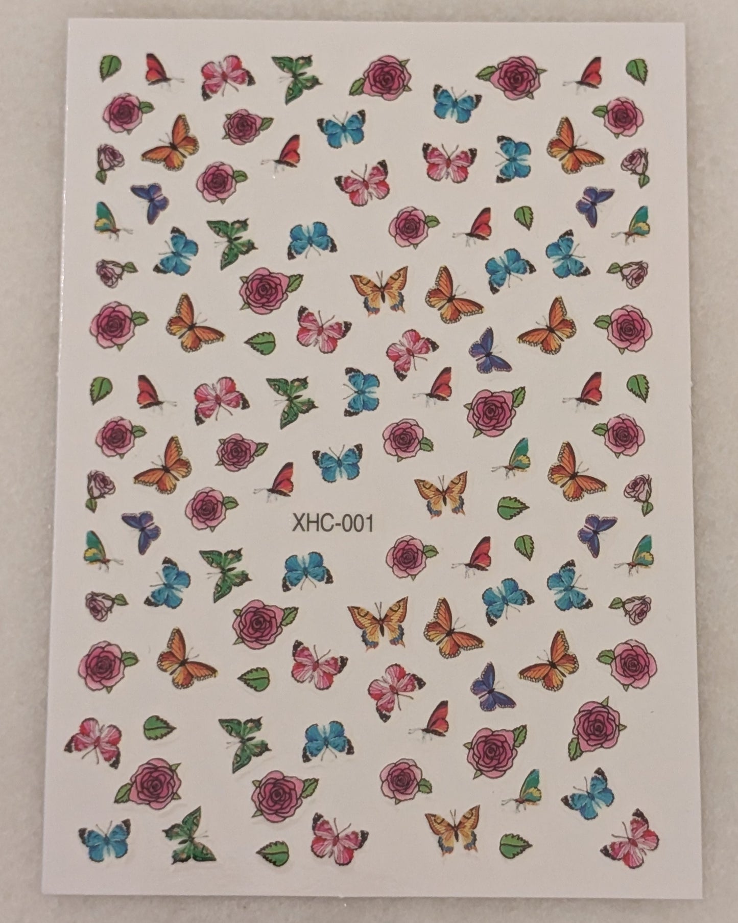 Nail art stickers with blue, yellow, orange, pink, purple and green butterflies along with pink roses and leaves.