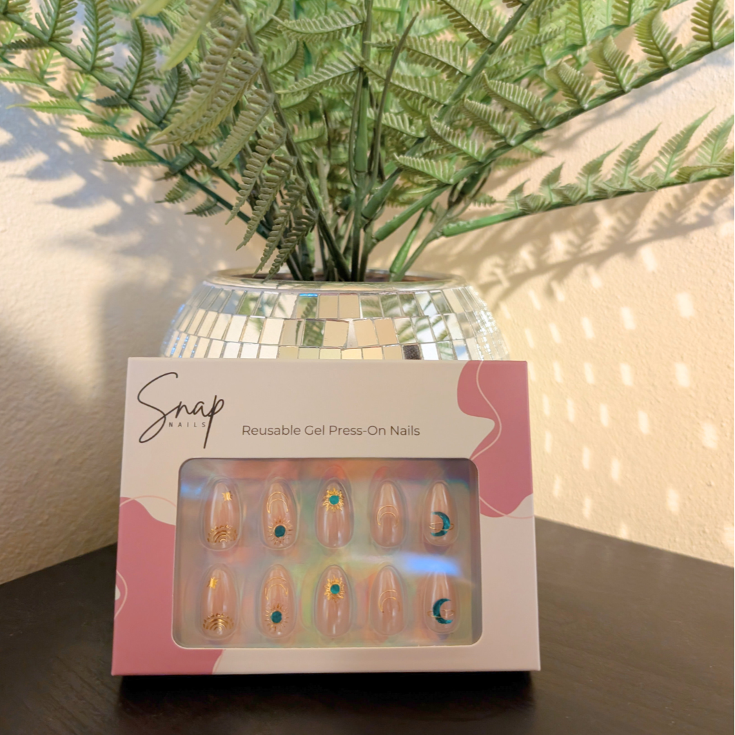 Image of box of Snap Nails in Signature collection of 10 almond peachy, shimmery nails with gold details.