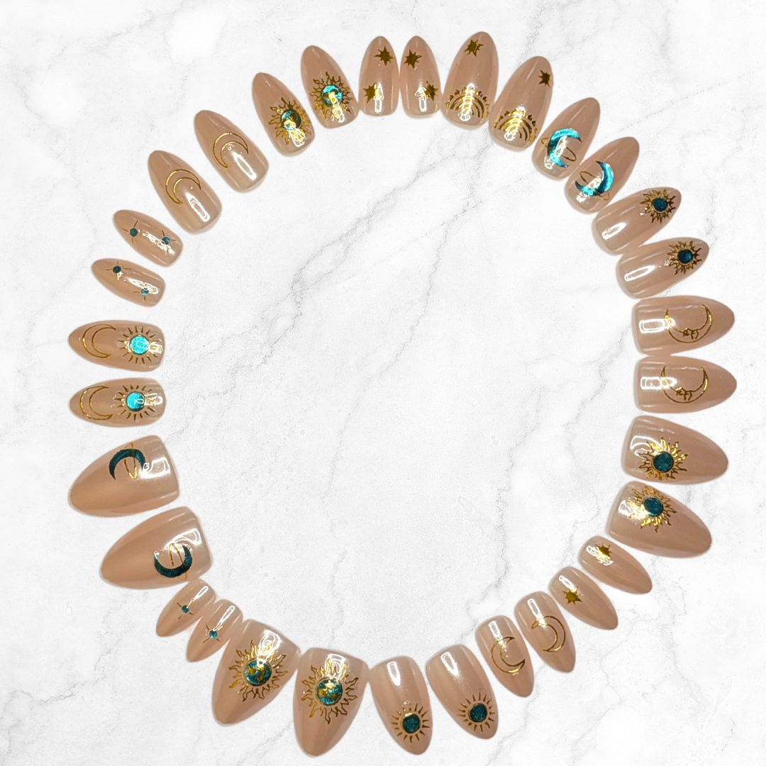 Image of 30 Snap Nails in Signature collection almond star dust nails with gold details arranged in a circle on a marble background.
