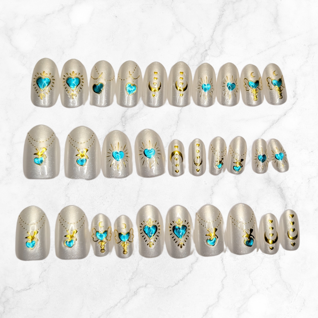 Image of 30 Snap Nails in Signature collection oval pear nails with gold details on a marble background.