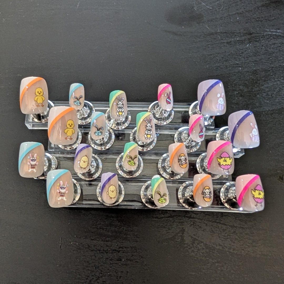 20 square nails of varying sizes that have easter bunny and chick details with swatches of colour.