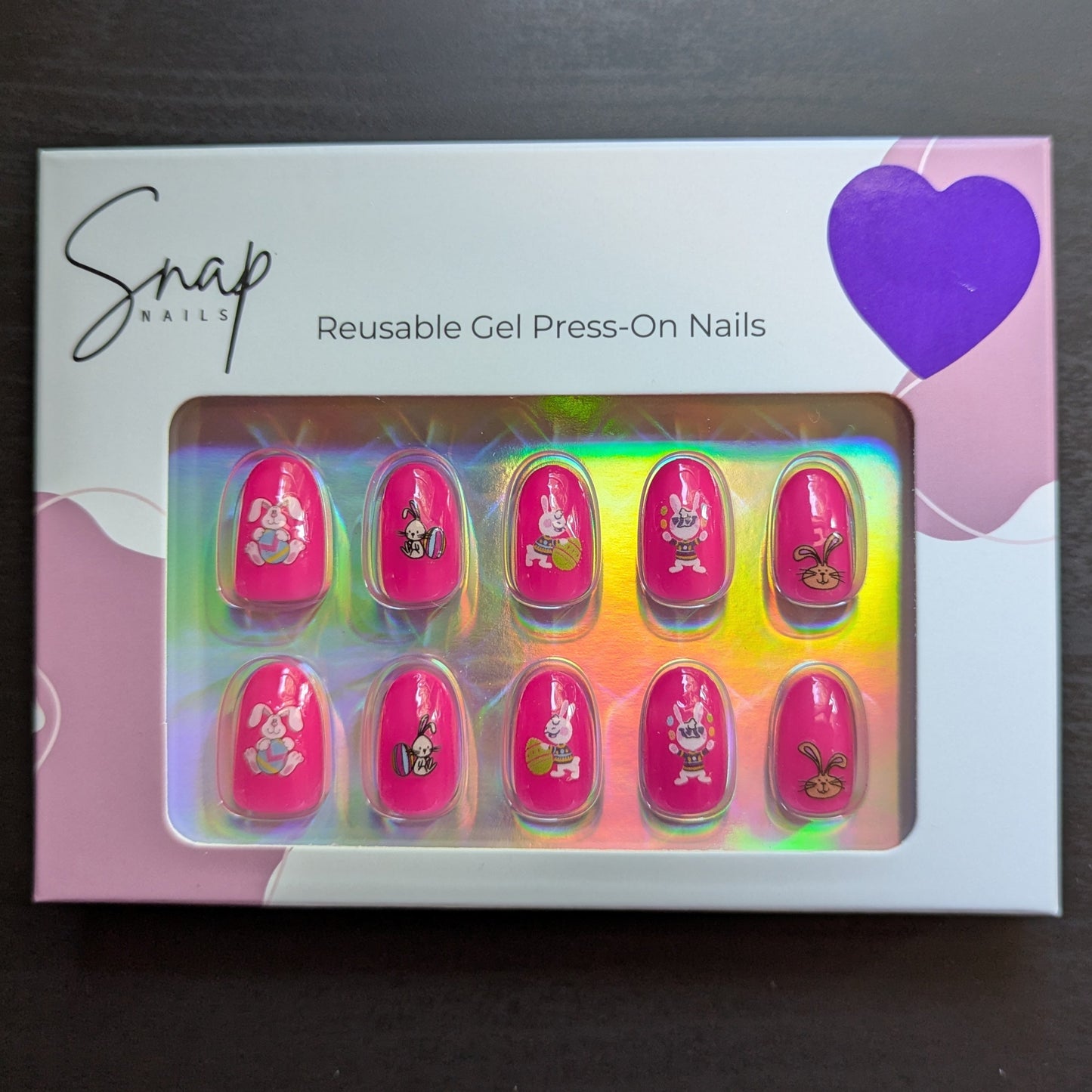Image of a Snap Nails box with 10 oval hot pink press on gel nails with various Easter designs.
