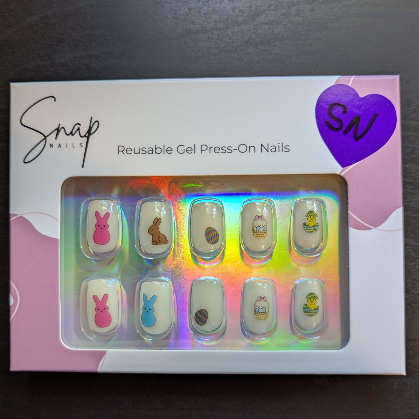 Image of a Snap Nails box with 10 square pearl press on gel nails with various Easter designs.
