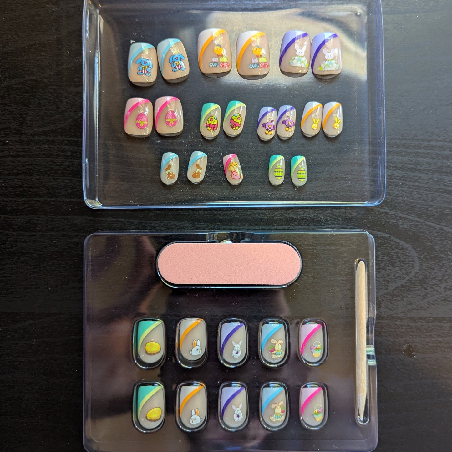 Image of a clear box with square gel press-ons with 19 nails of varying tip colours and Easter designs. Underneath is another clear box with 10 square press on gel nails with various tip colours and Easter designs, a cuticle stick and a nail file.