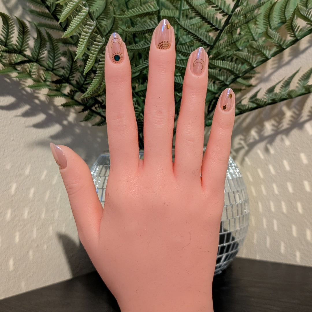 Image of a right hand wearing Snap Nails in Signature collection of 5 almond shimmery, peachy nails gold details.
