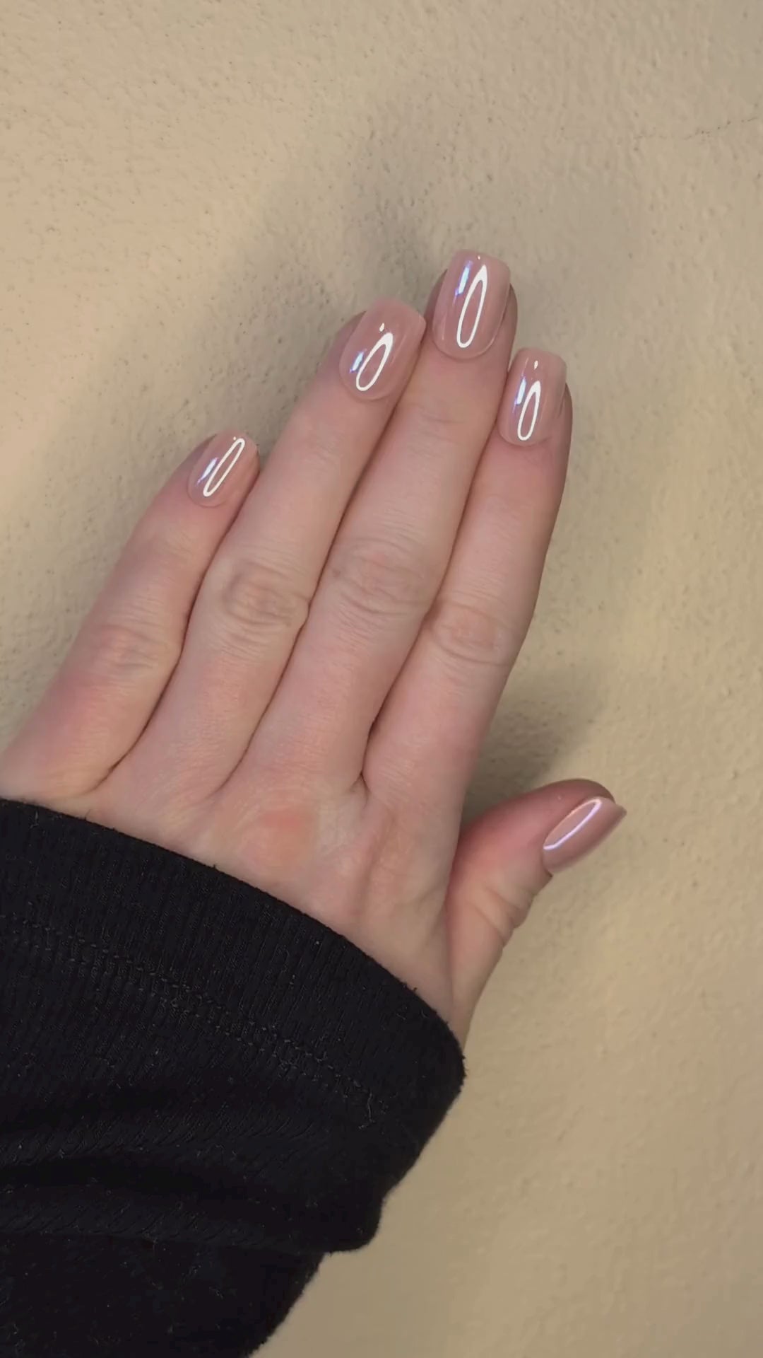 Left hand showing square nails in a metallic blush colour.