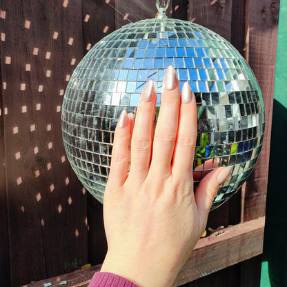 Left hand showing latte brown in our almond shape, with a slight shimmer, on disco ball.