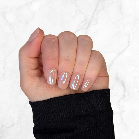 Left hand wearing a square blush nails on a marble background.