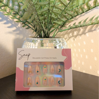 Image of box of Snap Nails in Signature collection of 10 almond peachy, shimmery nails with gold details. 
