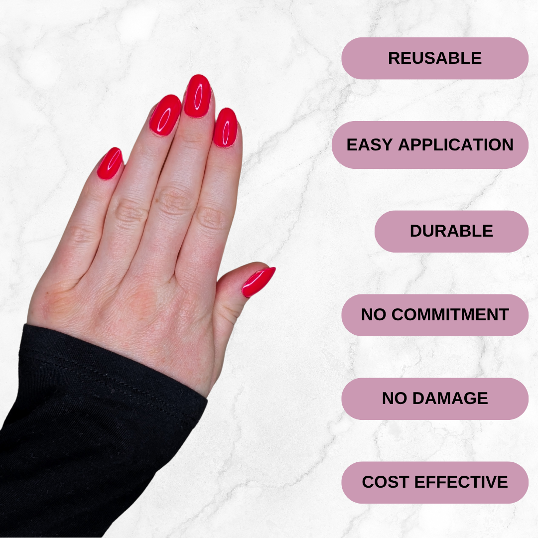 Left hand wearing oval cherry red nails on a marble background. Reusable, easy application, durable, no commitment, no damage, cost effective.
