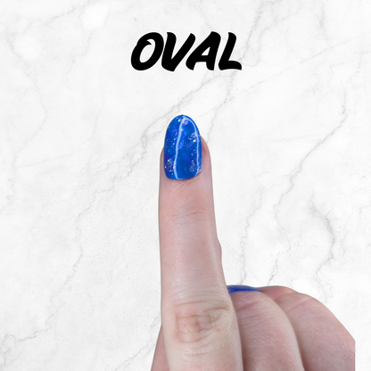 Finger wearing blue and purple marbled press-on nails with silver sparkle in an oval shape.