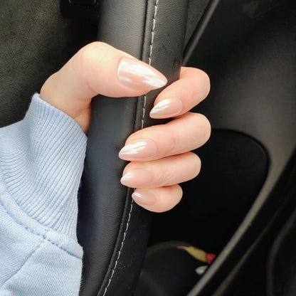 Left hand showing an almond shimmery, pinky peach coloured nails holding onto a car door handle.