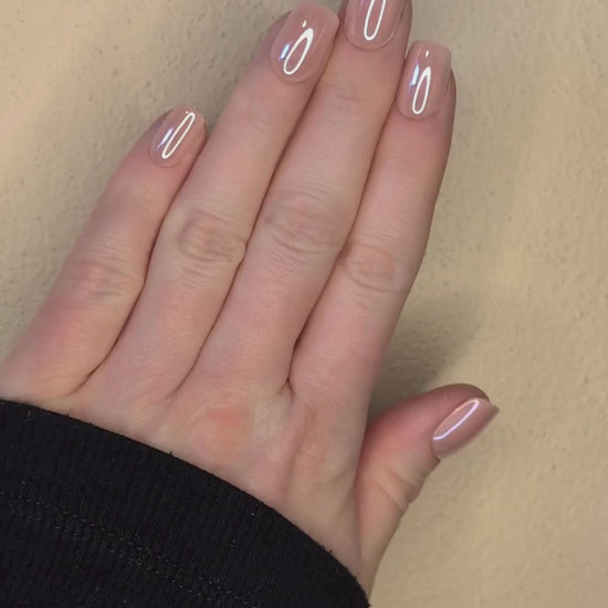 Left hand showing square nails in a metallic blush colour.
