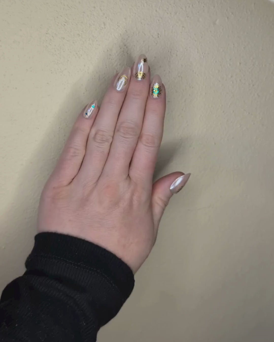 Video of a left hand wearing Snap Nails in Signature collection of 5 almond shimmery, peachy nails gold details